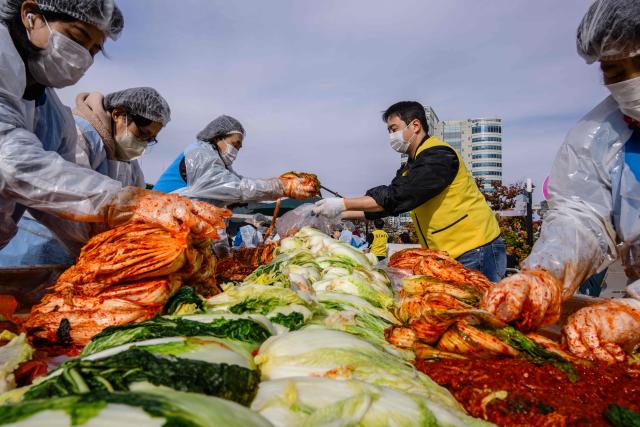 People take part in a kimchi making festival at Garak Market in Seoul on November 17, 2025. (Photo by ANTHONY WALLACE / AFP)