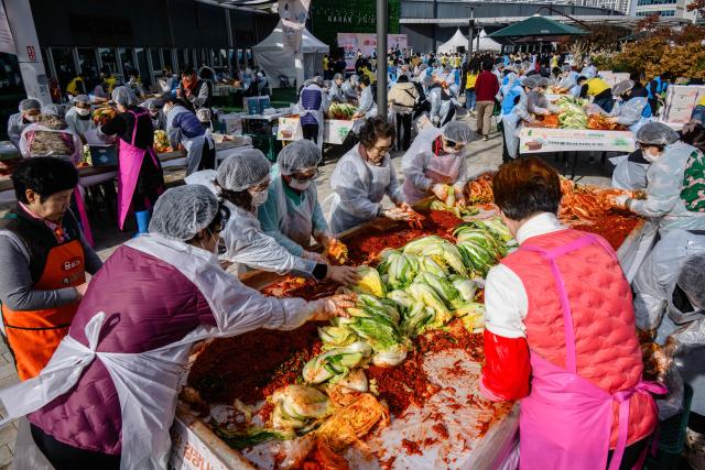 People take part in a kimchi making festival at Garak Market in Seoul on November 17, 2025. (Photo by ANTHONY WALLACE / AFP)