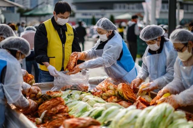 People take part in a kimchi making festival at Garak Market in Seoul on November 17, 2025. (Photo by ANTHONY WALLACE / AFP)