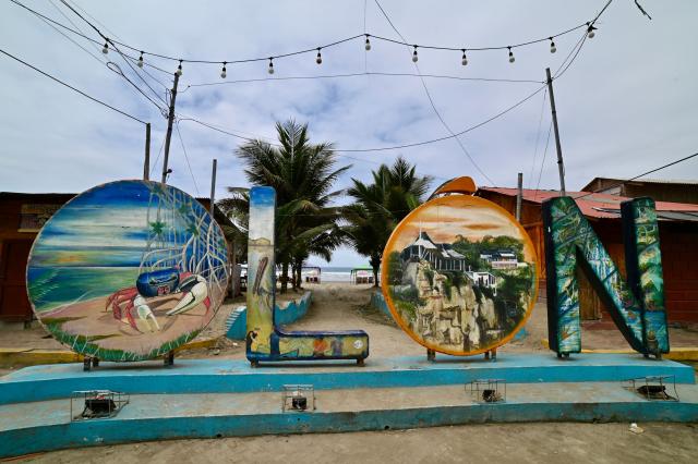 View of the body letters at the beach of Olon, Santa Elena, Ecuador, on November 17, 2025. Ecuadoran voters roundly rejected the return of US military bases to the country in a referendum Sunday, a major political blow to Trump-friendly President Daniel Noboa. (Photo by MARCOS PIN / AFP)