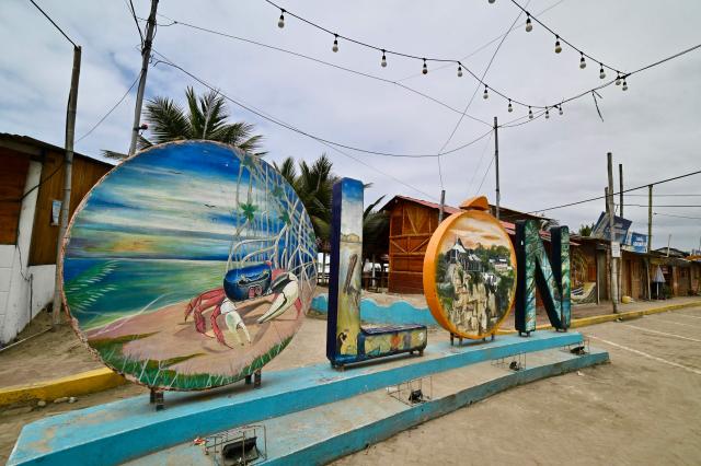 View of the body letters at the beach of Olon, Santa Elena, Ecuador, on November 17, 2025. Ecuadoran voters roundly rejected the return of US military bases to the country in a referendum Sunday, a major political blow to Trump-friendly President Daniel Noboa. (Photo by MARCOS PIN / AFP)