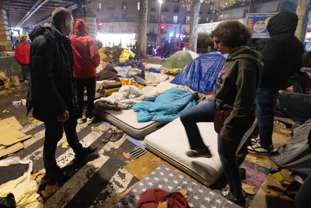 France's Culture minister and Les Republicains' candidate for mayor of Paris in the 2026 municipal elections, Rachida Dati (R) visits a migrants camp in the La Chapelle area in Paris on November 16, 2025, as part of her political campaign for the municipal elections in Paris. (Photo by Joël SAGET / AFP)