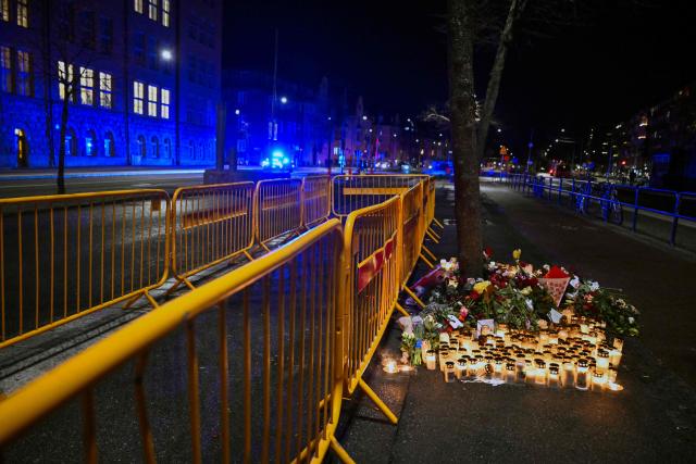 Mourners leave flowers and candles at the scene of an accident where three people died and several were injured when a bus crashed into a bus shelter in Oestermalm, Stockholm, on November 17, 2025. Two Swedish women and a woman from an unnamed European country have been identified as the three people killed when a bus ploughed into a Stockholm bus stop queue last week, police said on November 17. (Photo by Pontus LUNDAHL / TT NEWS AGENCY / AFP) / Sweden OUT