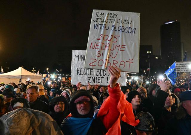 A demonstrator holds a placard reading "1989 unity of people welcome freedom, 2025 let's not take it away", during a protest against the government of Slovakia's nationalist Kremlin-friendly Prime Minister Robert Fico on November 17, 2025 in Bratislava, Slovakia. Students of a highscool in Poprad had left the room during a speech of Fico on November 14, 2025 at their institution to signal dissent. Czechs and Slovaks rally in both countries, the anniversary of the 1989 Velvet Revolution that toppled communism in former Czechoslovakia, to denounce the leaders they say have betrayed its legacy. On November 17, 1989, communist police brutally crushed a peaceful student march in the centre of Prague, sparking an uprising that toppled the Moscow-steered regime after four decades. Like in the other Soviet-bloc countries at the time, the revolution restored democracy in Czechoslovakia, which then split into the Czech Republic and Slovakia four years later. (Photo by Joe Klamar / AFP)