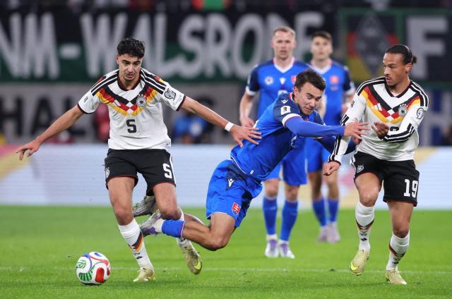 (L-R) Germany's midfielder #05 Aleksandar Pavlovic, Slovakia's forward #15 David Strelec and Germany's midfielder #19 Leroy Sane vie for the ball during the FIFA World Cup 2026 European qualification Group A football match between Germany and Slovakia, at the Red Bull Arena in Leipzig, eastern Germany on November 17, 2025. (Photo by Ronny HARTMANN / AFP)