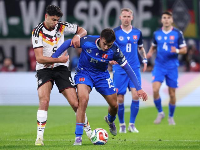 Germany's midfielder #05 Aleksandar Pavlovic (L) and Slovakia's forward #15 David Strelec vie for the ball during the FIFA World Cup 2026 European qualification Group A football match between Germany and Slovakia, at the Red Bull Arena in Leipzig, eastern Germany on November 17, 2025. (Photo by Ronny HARTMANN / AFP)