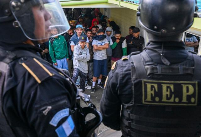 Mara Salvatrucha gang members wait during a riad at Pavoncito prision in Fraijanes, Guatemala on November 17, 2025. The operation is part of measures announced by the new security authorities to regain control of the country's prisons following the October escape of 20 Barrio 18 gang leaders from Fraijanes II Prison, adjacent to Pavoncito. (Photo by JOHAN ORDONEZ / AFP)