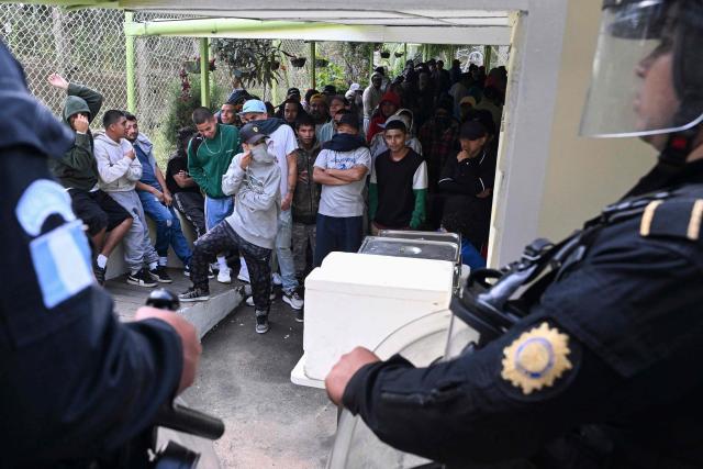 Mara Salvatrucha gang members wait during a riad at Pavoncito prision in Fraijanes, Guatemala on November 17, 2025. The operation is part of measures announced by the new security authorities to regain control of the country's prisons following the October escape of 20 Barrio 18 gang leaders from Fraijanes II Prison, adjacent to Pavoncito. (Photo by JOHAN ORDONEZ / AFP)