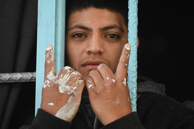 A Mara Salvatrucha gang member makes a gang sign during a raid in Pavoncito Prison in Fraijanes, Guatemala on November 17, 2025. The operation is part of measures announced by the new security authorities to regain control of the country's prisons following the October escape of 20 Barrio 18 gang leaders from Fraijanes II Prison, adjacent to Pavoncito. (Photo by Johan ORDONEZ / AFP)