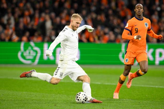 Lithuania's goalkeeper #01 Edvinas Gertmonas (L) clears the ball in front of Netherland's forward #09 Emmanuel Emegha (R) during the FIFA World Cup 2026 Group G European qualification football match between the Netherlands and Lithuania at the Johan Cruijff Arena, in Amsterdam, on November 17, 2025. (Photo by JOHN THYS / AFP)