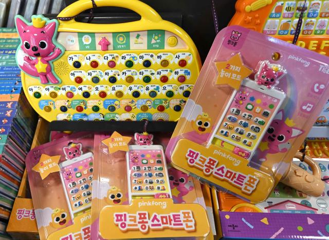 Pinkfong soundpad products are displayed at a bookstore in Seoul on November 18, 2025. The Pinkfong Company, the South Korean studio behind the global hit "Baby Shark", surged more than 30 percent above its offering price in early trading on November 18, as it made its debut on the local market. (Photo by Jung Yeon-je / AFP)
