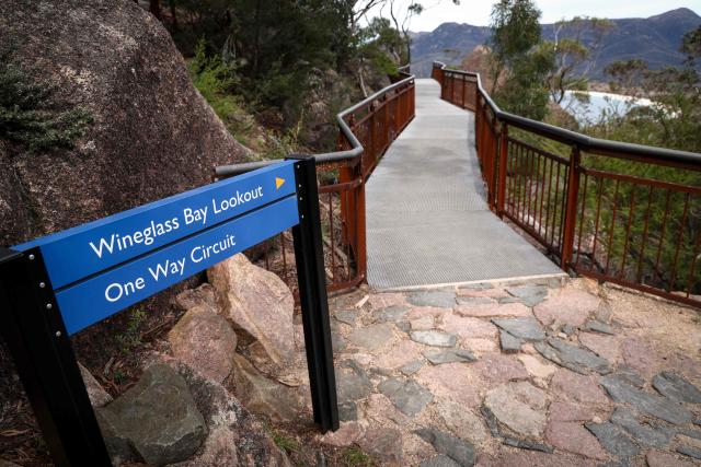 This picture taken on November 5, 2025 shows a sign displayed at a lookout located above Wineglass Bay at Freycinet Peninsula in Tasmania’s Freycinet National Park. (Photo by DAVID GRAY / AFP)