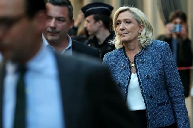 (FILES) President of the parliamentary group of the French far-right Rassemblement National (RN) party, Marine Le Pen (R) leaves the headquarters of the French far-right Rassemblement National (RN) party, after a French court sentenced her to a five-year ban on running for office and a prison term in a trial on charges of embezzlement of European public funds, in Paris on March 31, 2025. (Photo by Thomas SAMSON / AFP)