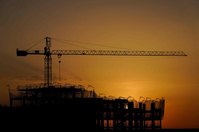 The sun rises behind a construction site of residential apartment blocks in the Valdebebas urban development area in Madrid, Spain, on Thursday, June 25, 2020. (Photo by Paul Hanna / AFP)