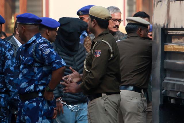Security personnel escort alleged car blast accused Jasir Bilal Wani (C) as he was produced at Patiala House Court, in New Delhi on November 18, 2025. The agency said Jasir Bilal Wani had "allegedly provided technical support for carrying out terror attacks by modifying drones and attempting to make rockets" ahead of the blast. (Photo by AFP)