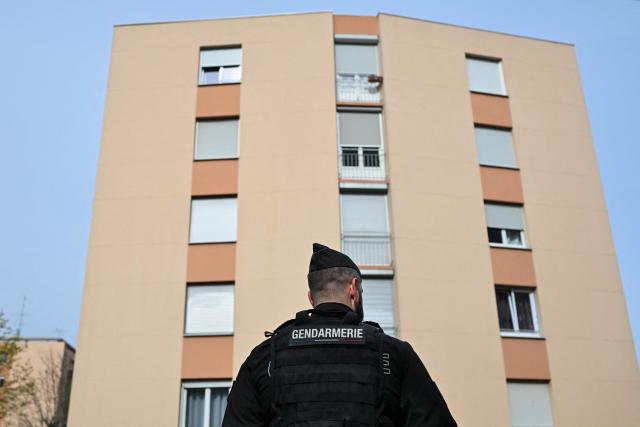 (FILES) A French gendarme stand in front of an apartment building during the "XXL cleanup operation" launched simultaneously in several towns across the country to fight drug trafficking, in Chenove, near Dijon, central eastern France, on March 25, 2024. France's President Emmanuel Macron on November 18, 2025, urged more measures against drug crime during a meeting organised following several criminal incidents in recent days, including the murder of the brother of an environmental activist. (Photo by ARNAUD FINISTRE / AFP)