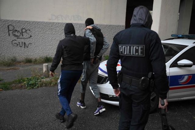 (FILES) Police officers from the BST 14 Brigade arrest a suspected member of a drug trafficking network at Les Rosiers housing project, in the northern districts of Marseille, southern France, on December 1, 2023. France's President Emmanuel Macron on November 18, 2025, urged more measures against drug crime during a meeting organised following several criminal incidents in recent days, including the murder of the brother of an environmental activist. (Photo by Nicolas TUCAT / AFP)