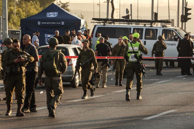 Israeli security forces stand next to a damaged car at the scene of a reported attack at the Gush Etzion Junction, in the Israeli-occupied West Bank, on November 18, 2025. The area of Gush Etzion Junction in the southern West Bank has seen repeated attacks against Israelis in recent years. (Photo by Ahmad GHARABLI / AFP)