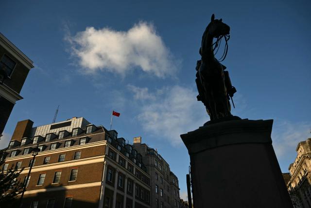 A flag flies atop a pole on the roof of the Embassy of the People's Republic of China in the United Kingdom, on Portland Place in London on November 18, 2025. Britain's domestic intelligence agency MI5 on November 18, warned that China was trying to recruit parliamentarians through spies disguised as headhunters, amid concern over Beijing's activities in the UK. There have been heightened fears about Chinese espionage in the UK after a politically sensitive case against two alleged spies was dropped, and as the government mulls a request from Beijing to build a controversial new embassy building in London. (Photo by JUSTIN TALLIS / AFP)