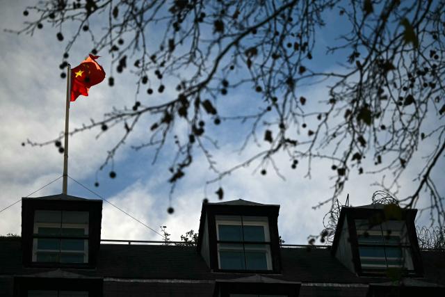 A flag flies atop a pole on the roof of the Embassy of the People's Republic of China in the United Kingdom, on Portland Place in London on November 18, 2025. Britain's domestic intelligence agency MI5 on November 18, warned that China was trying to recruit parliamentarians through spies disguised as headhunters, amid concern over Beijing's activities in the UK. There have been heightened fears about Chinese espionage in the UK after a politically sensitive case against two alleged spies was dropped, and as the government mulls a request from Beijing to build a controversial new embassy building in London. (Photo by JUSTIN TALLIS / AFP)