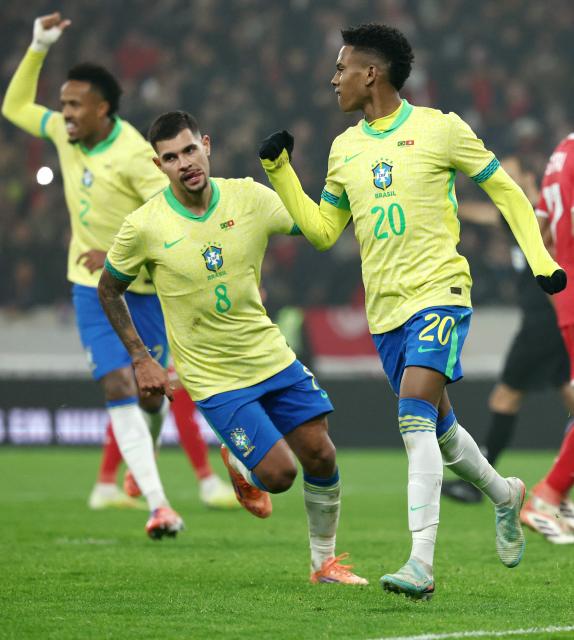 Brazil's forward #20 Estevao (R) celebrates after scoring Brazil's first goal from the penalty spot during the International friendly football match between Brazil and Tunisia at Stade Pierre-Mauroy, in Villeneuve-d'Ascq, northern France, on November 18, 2025. (Photo by FRANCK FIFE / AFP)