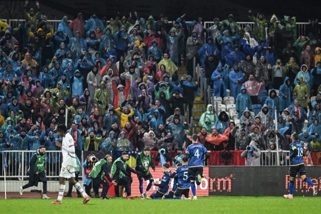 TOPSHOT - Kosovo's midfielder #08 Florent Muslija (C) celebrates with teammates and supporters  after scoring  his team's first goal  during the FIFA World Cup 2026 European qualification Group B football between Kosovo and Switzerland at the Fadil Vokrri Stadium in Pristina, on November 18, 2025. (Photo by Armend NIMANI / AFP)