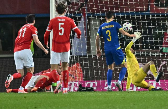 Austria's forward #11 Michael Gregoritsch (L) scores the equalizer during the FIFA World Cup 2026 European qualification Group H football match between Austria and Bosnia and Herzegovina, in Vienna on November 18, 2025. (Photo by Joe Klamar / AFP)