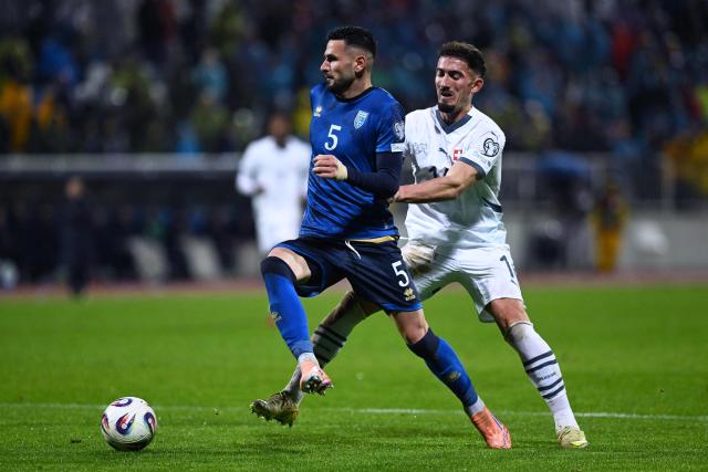 Kosovo's midfielder #05 Lumbardh Dellova (L) fights for the ball with Switzerland's forward #14 Andi Zeqiri  during the FIFA World Cup 2026 European qualification Group B football between Kosovo and Switzerland at the Fadil Vokrri Stadium in Pristina, on November 18, 2025. (Photo by Armend NIMANI / AFP)