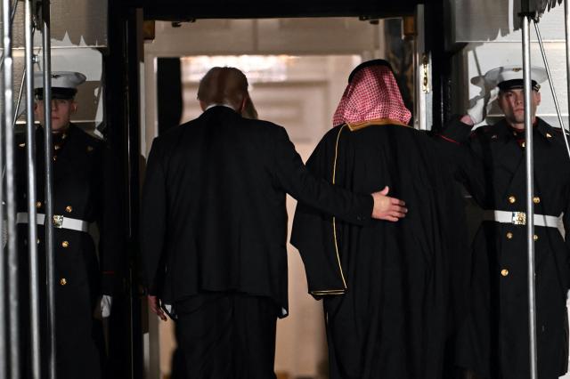 The Crown Prince and Prime Minister of the Kingdom of Saudi Arabia Mohammed bin Salman (R) is welcomed by US President Donald Trump to attend a state dinner at the White House in Washington, DC on November 18, 2025. (Photo by ANDREW CABALLERO-REYNOLDS / AFP)
