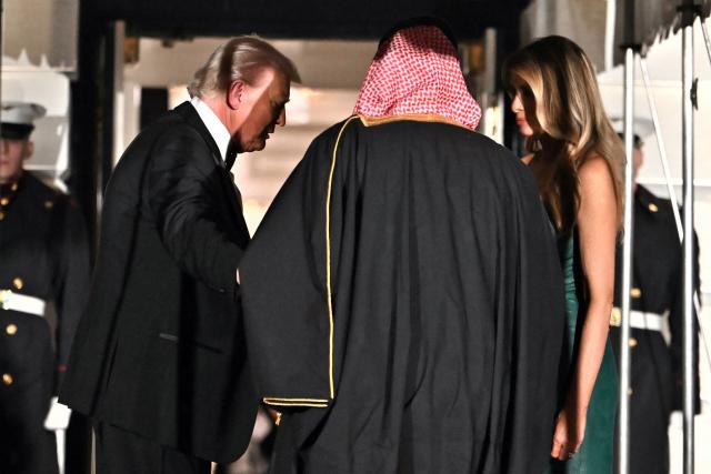 The Crown Prince and Prime Minister of the Kingdom of Saudi Arabia Mohammed bin Salman (C) is welcomed by US President Donald Trump and First Lady Melania Trump to attend a state dinner at the White House in Washington, DC on November 18, 2025. (Photo by ANDREW CABALLERO-REYNOLDS / AFP)