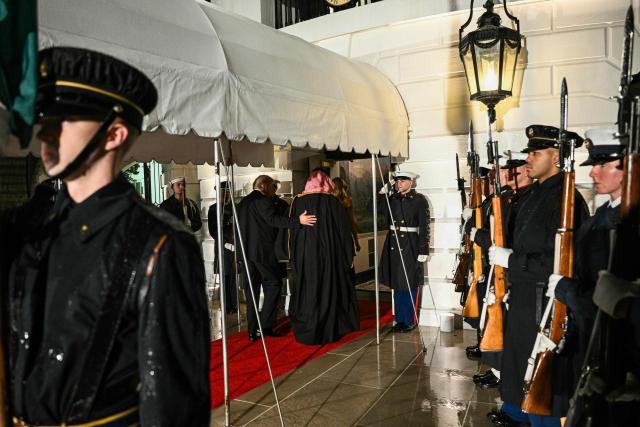 The Crown Prince and Prime Minister of the Kingdom of Saudi Arabia Mohammed bin Salman (R) is welcomed by US President Donald Trump to attend a state dinner at the White House in Washington, DC on November 18, 2025. (Photo by Brendan SMIALOWSKI / AFP)