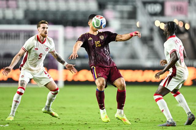 Venezuela's forward #19 Kevin Kelsy fights for the ball with Canada's midfielders #05 Joel Waterman and #08 Ismael Kone during the international friendly football match between Canada and Venezuela at Chase Stadium in Fort Lauderdale, Florida, on November 18, 2025. (Photo by CHANDAN KHANNA / AFP)