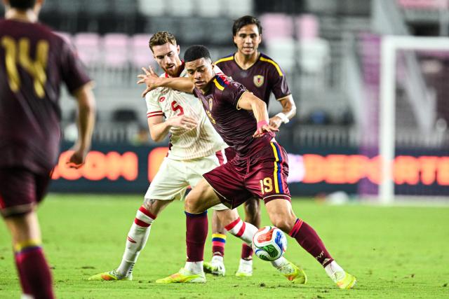 Venezuela's forward #19 Kevin Kelsy fights for the ball with Canada's #05 Joel Waterman (L) during the international friendly football match between Canada and Venezuela at Chase Stadium in Fort Lauderdale, Florida, on November 18, 2025. (Photo by CHANDAN KHANNA / AFP)