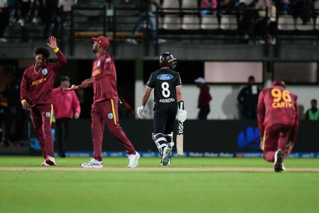 New Zealand's Rachin Ravindra (C) walks from the field after being caught as West Indies' players celebrate during the second one-day international cricket match between New Zealand and the West Indies at McLean Park in Napier on November 19, 2025. (Photo by Marty MELVILLE / AFP)