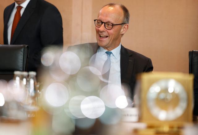 German Chancellor Friedrich Merz laughs as he prepares for the weekly meeting of the German cabinet at the Chancellery in Berlin on November 19, 2025. (Photo by Odd ANDERSEN / AFP)