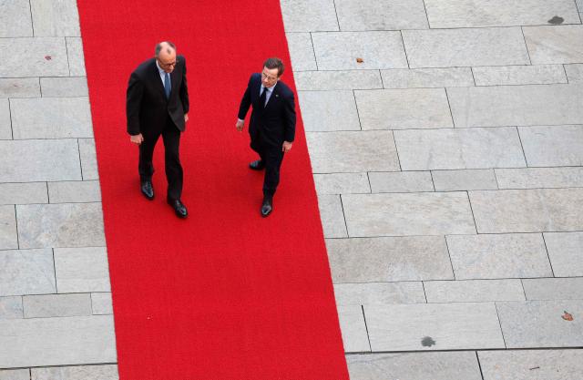 German Chancellor Friedrich Merz (L) and Sweden's Prime Minister Ulf Kristersson review a military honor guard in front of the Chancellery in Berlin on November 19, 2025. (Photo by Odd ANDERSEN / AFP)