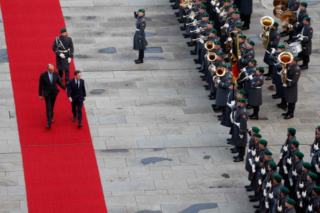 German Chancellor Friedrich Merz (L) and Sweden's Prime Minister Ulf Kristersson review a military honor guard in front of the Chancellery in Berlin on November 19, 2025. (Photo by Odd ANDERSEN / AFP)
