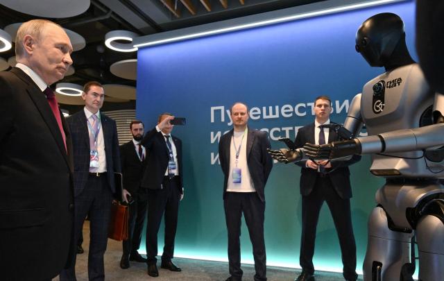 In this pool photograph distributed by the Russian state agency Sputnik, Russia's President Vladimir Putin visits an exhibition of the AI Journey international AI (Artificial intelligence) conference in Moscow on November 19, 2025. (Photo by Kristina Kormilitsyna / POOL / AFP)