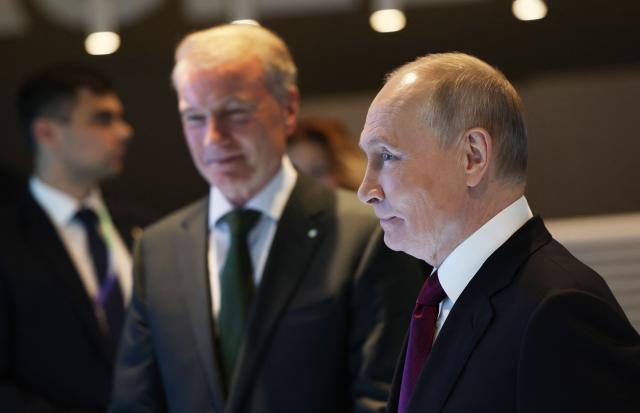 In this pool photograph distributed by the Russian state agency Sputnik, Russia's President Vladimir Putin, accompanied by Sberbank's CEO German Gref, visits an exhibition of the AI Journey international AI (Artificial intelligence) conference in Moscow on November 19, 2025. (Photo by Vyacheslav PROKOFYEV / POOL / AFP)