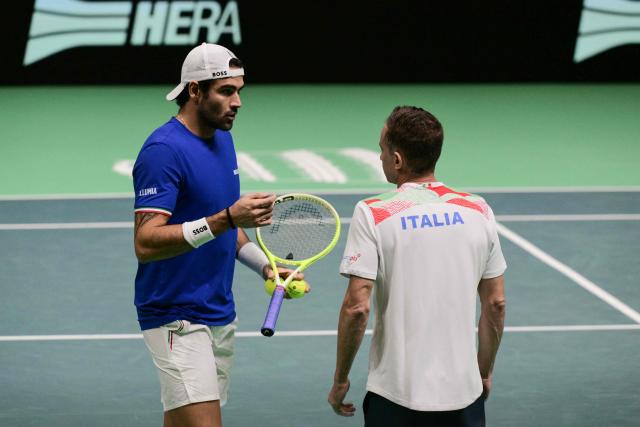 Italy's Matteo Berretini (L) speaks with Italy's coach Filippo Volandri during his Davis Cup men's singles quarter finals tennis match against Austria's Jurij Rodionov, at the Super Tennis Arena, in Bologna, northen Italy, on November 19, 2025. (Photo by Tiziana FABI / AFP)