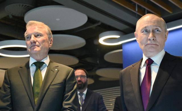 In this pool photograph distributed by the Russian state agency Sputnik, Russia's President Vladimir Putin, accompanied by Sberbank's CEO German Gref, visits an exhibition of the AI Journey international AI (Artificial intelligence) conference in Moscow on November 19, 2025. (Photo by Kristina Kormilitsyna / POOL / AFP)