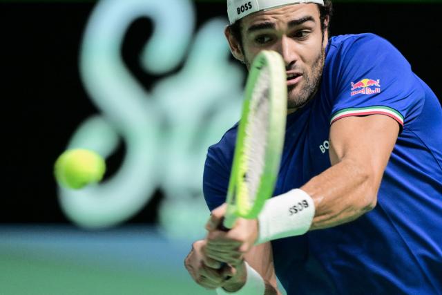 Italy's Matteo Berretini plays a backhand return to Austria's Jurij Rodionov during their Davis Cup men's singles quarter finals tennis match, at the Super Tennis Arena, in Bologna, northen Italy, on November 19, 2025. (Photo by Tiziana FABI / AFP)
