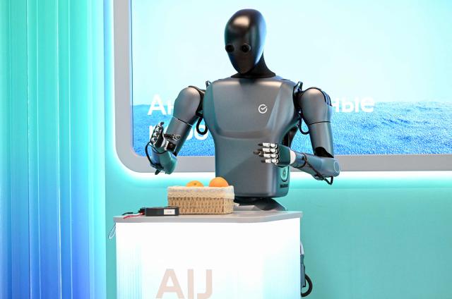 In this pool photograph distributed by the Russian state agency Sputnik, Russia's anthropomorphic AI-equipped robot developed by technology company Sber is pictured at an exhibition of the AI Journey international AI (Artificial intelligence) conference in Moscow on November 19, 2025. (Photo by Kristina Kormilitsyna / POOL / AFP)
