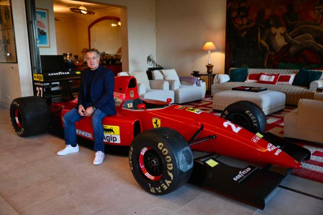 Former racing driver Jean Alesi sits on his 1992 Ferrari Formule 1 car in his living room, in Villeneuve-les-Avignon, southern France, on November 19, 2025. Jean Alesi prepares to auction one of his 1992 Ferrari Formula 1 cars, a unique piece estimated to be worth several million euros, auction house Artcurial told AFP on October 13, 2025. The auction, during which 65 luxury cars will be sold, will take place on January 27 at the Peninsula Hotel in Paris. (Photo by Christophe SIMON / AFP)