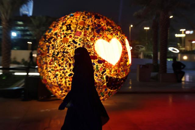 A woman walks past a light installation during the opening ceremony of the annual light art festival Noor Riyadh on November 19, 2025. (Photo by Fayez Nureldine / AFP)