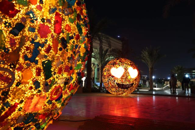 People walk past light installations during the opening ceremony of the annual light art festival Noor Riyadh on November 19, 2025. (Photo by Fayez Nureldine / AFP)