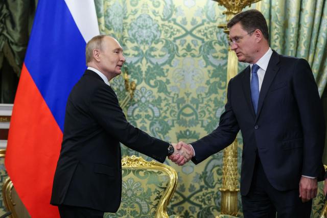 Russia's President Vladimir Putin shakes hands with Deputy Prime Minister Alexander Novak as Putin and Togo's President of the Council of Ministers Faure Gnassingbe (not pictured) meet at the Kremlin in Moscow on November 19, 2025. (Photo by Ramil Sitdikov / POOL / AFP)
