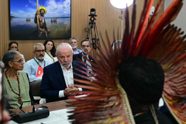 TOPSHOT - Brazil's President Luiz Inácio Lula da Silva (C) speaks during a meeting with civil society members and Indigenous leaders, alongside Environment Minister Marina Silva (L),  at the COP30 UN Climate Change Conference in Belem, Pare State, Brazil, on November 19, 2025. COP30 host Brazil pushed Tuesday for an early breakthrough at UN climate talks, with nations weighing a proposed deal that seeks to bridge major differences on fossil fuels, finance and trade barriers. Brazil wants an agreement reached by midweek, with President Luiz Inacio Lula da Silva to make an unexpected return on Wednesday to Belem, the host city in the country's Amazon region, in a high-level bid to seal a deal. (Photo by Pablo PORCIUNCULA / AFP)
