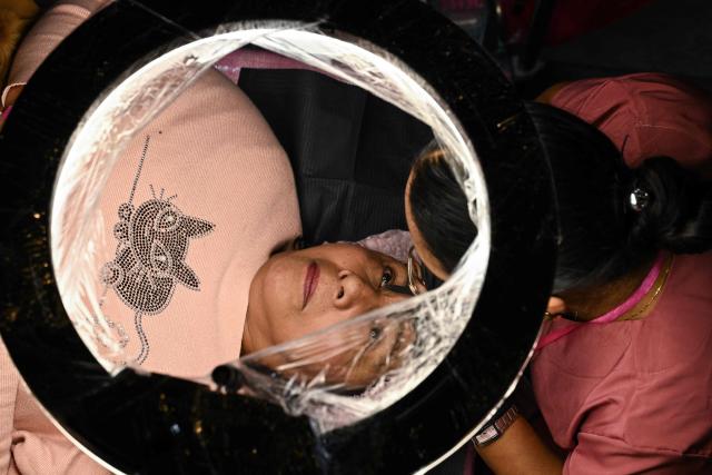 A cancer patient receives care during a free beauty and oncological micropigmentation event called "Delineating Smiles" in Mexico City's Iztapalapa neighborhood on November 19, 2025. The "Delineating Smiles" event offered therapeutic care to women with cancer from 30 artists and professionals, including lash technicians, microblading specialists, tattoo artists and psychologists. (Photo by Yuri CORTEZ / AFP)
