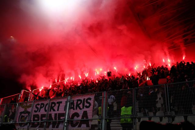 Benficia's supporters light smoke flares as they cheer on their team during the UEFA Women's Champions League first round day 4 football match between Paris FC and SL Benficia at the Stade Jean Bouin in Paris on November 19, 2025. (Photo by FRANCK FIFE / AFP)